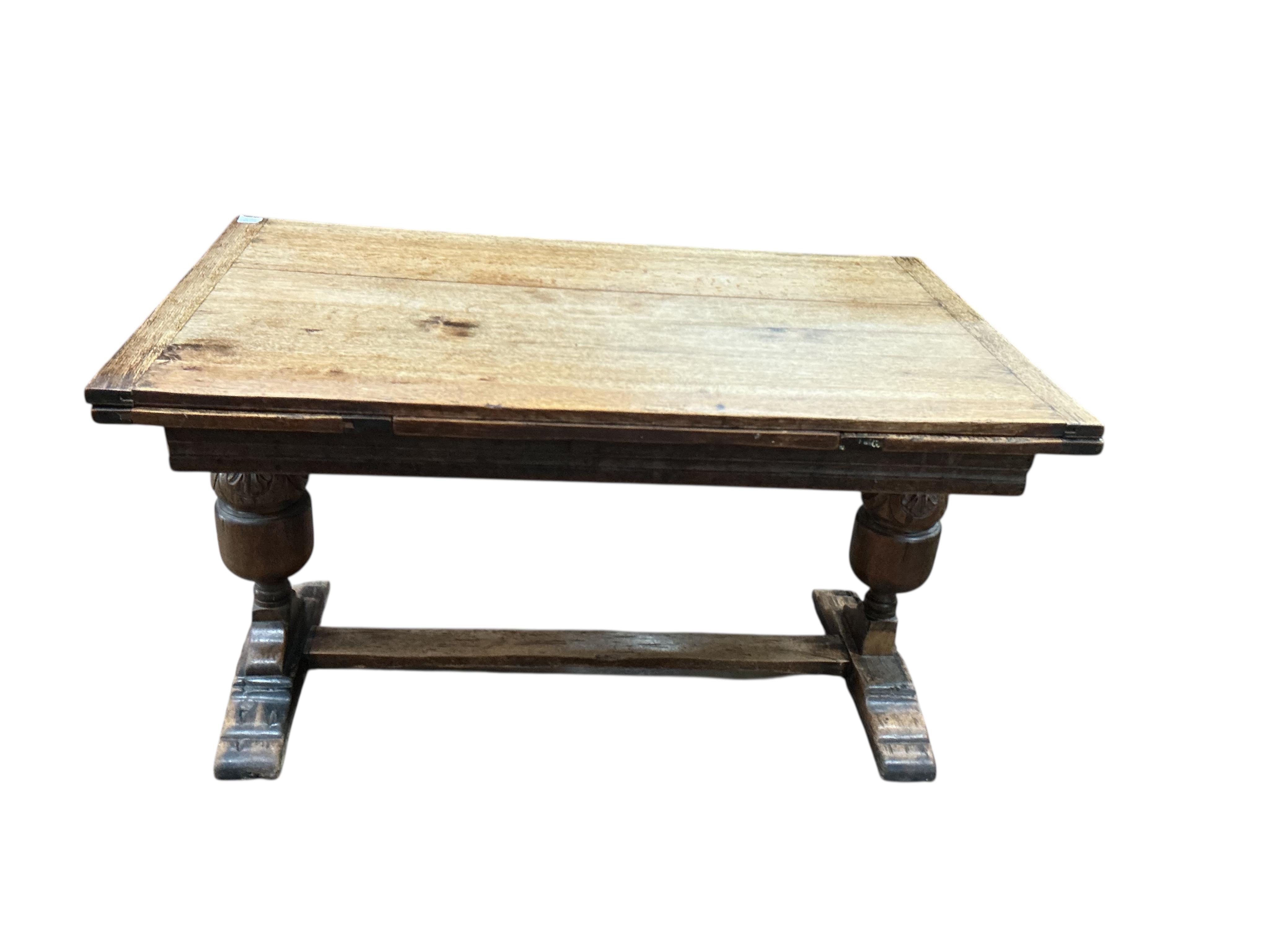 An 18th century style rectangular oak extending draw leaf refectory table, width 136cm, depth 80cm, height 78cm together with four carved oak dining chairs